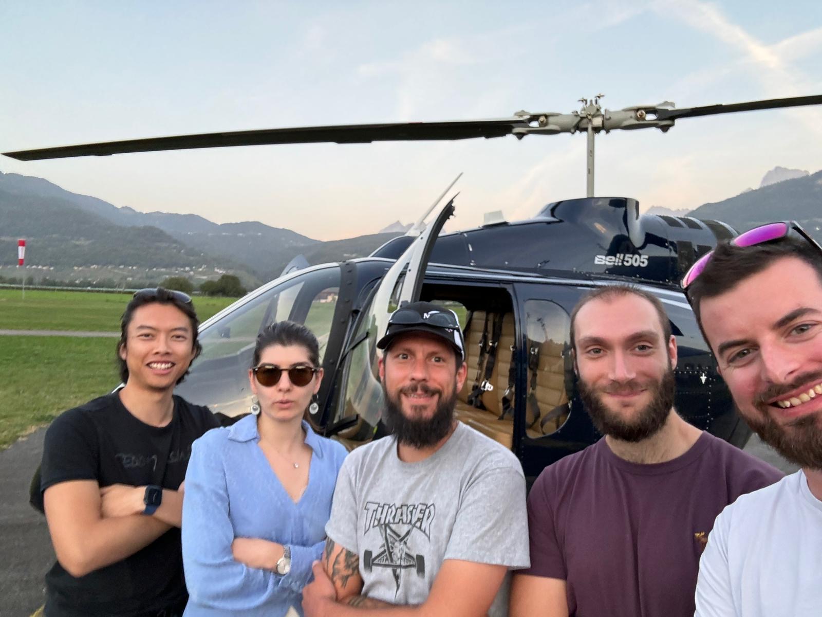 Photo de groupe devant l’hélicoptère après un vol glacier3000 dans les alpes valaisannes – Heli3000