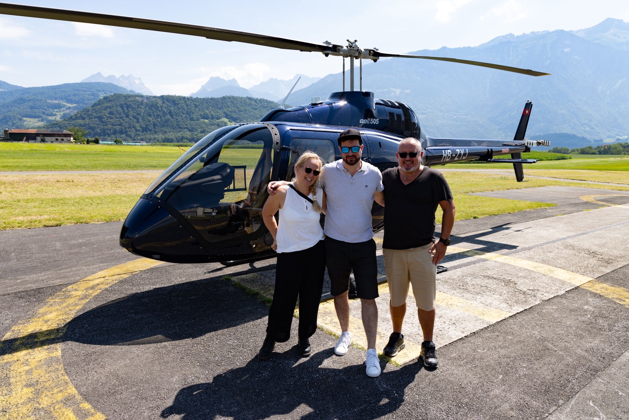 Passagers et pilote posant devant l’hélicoptère a Bex dans le Chablais du canton de Vaud – Heli3000