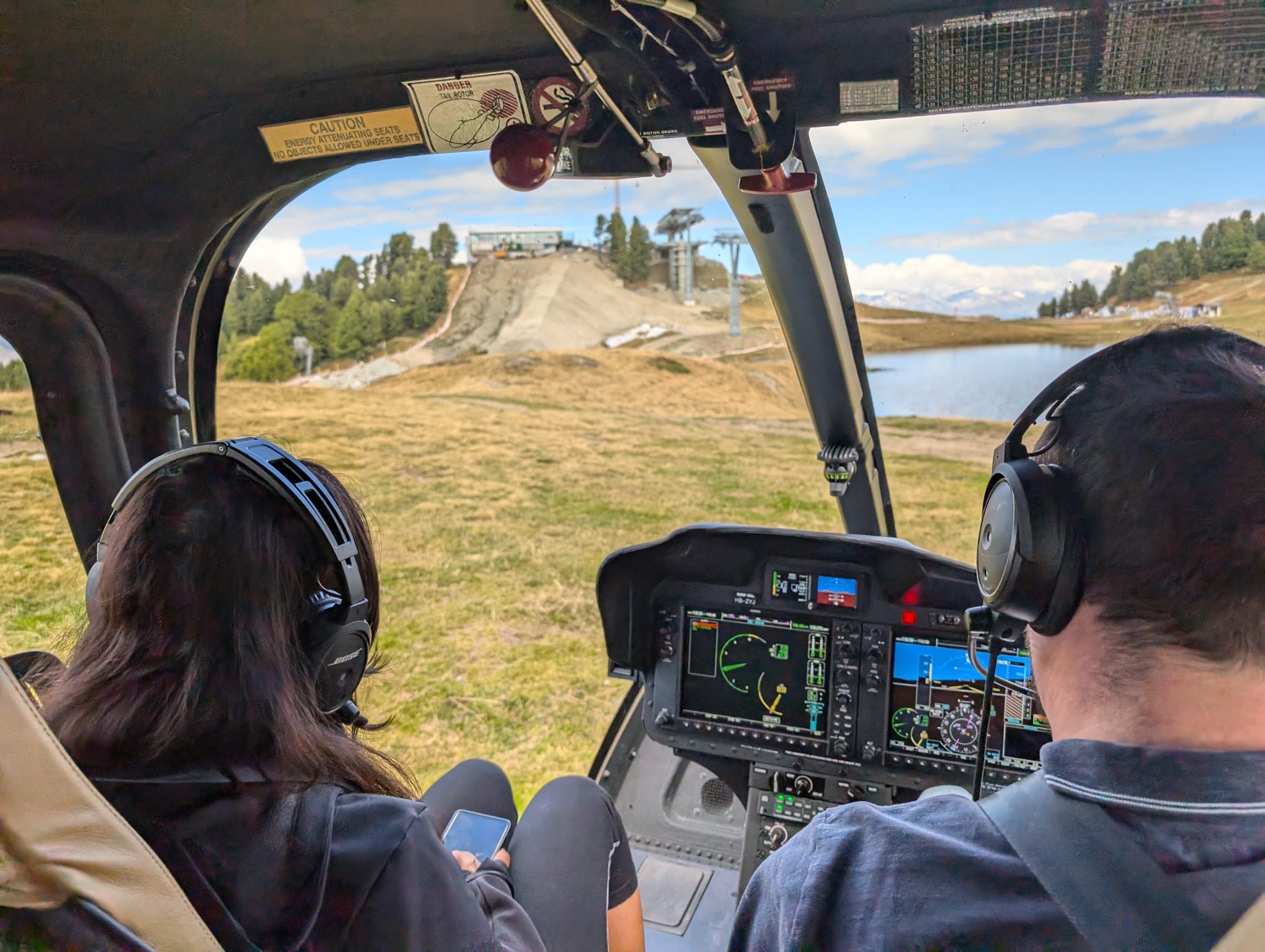 Passagers observant les montagnes depuis l’hélicoptère a Tracouet au dessus de Nendaz pour un vol cadeau – Heli3000